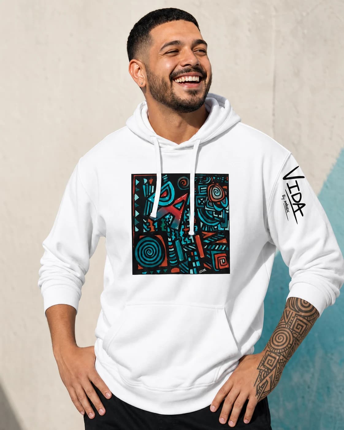 VIDA campaign mockup: joyful portrait wearing Mènek’s art on a white hoodie