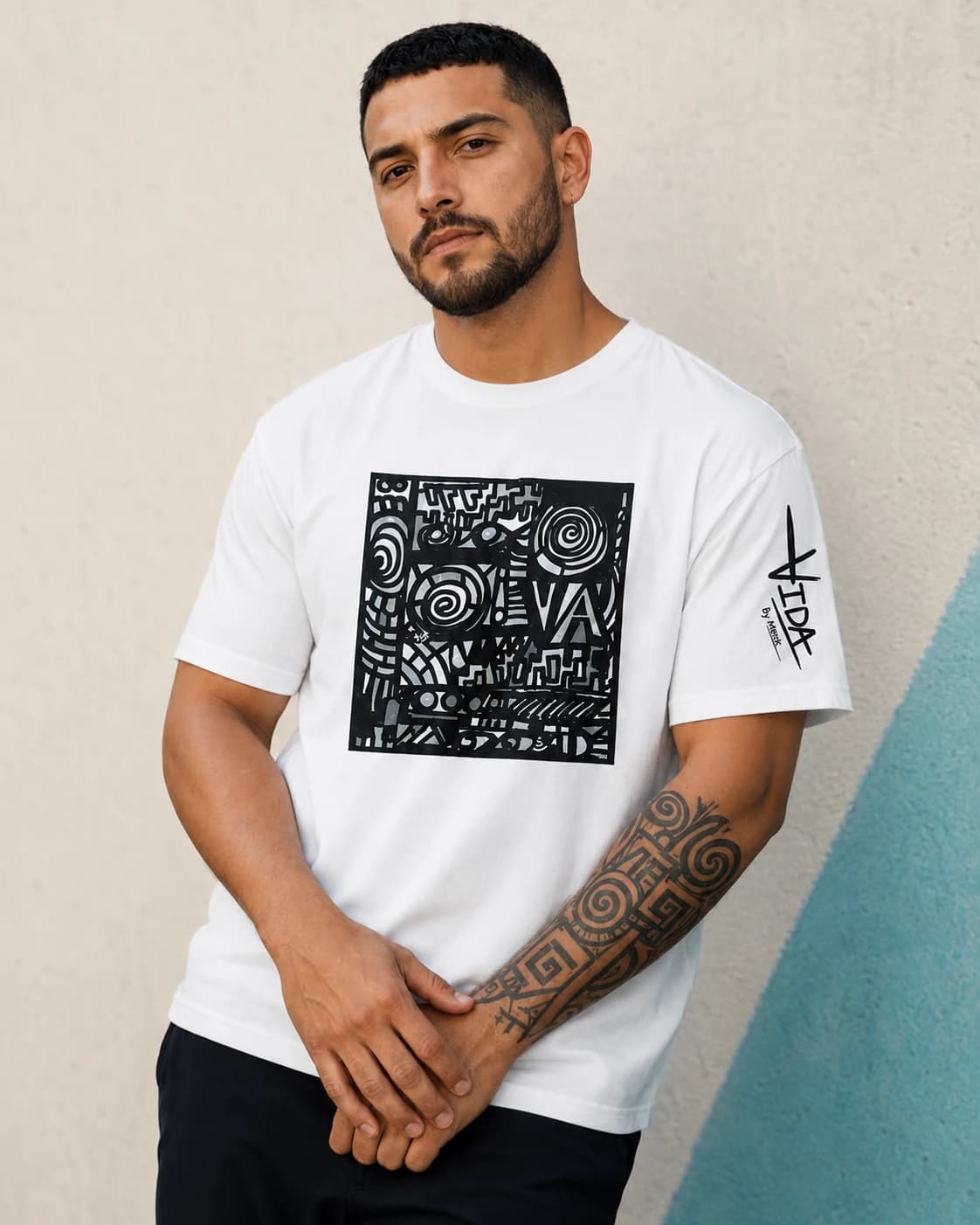 VIDA campaign mockup: Tinta artwork on a white tee against a quiet concrete backdrop